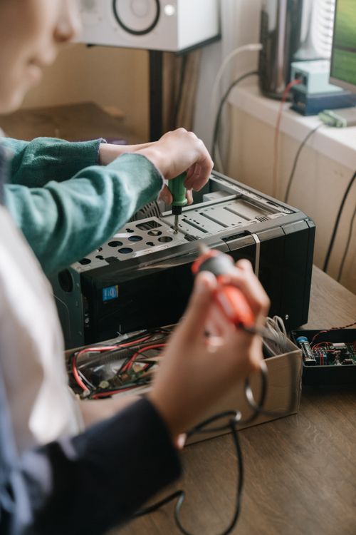 Technicians repairing computer hardware with tools