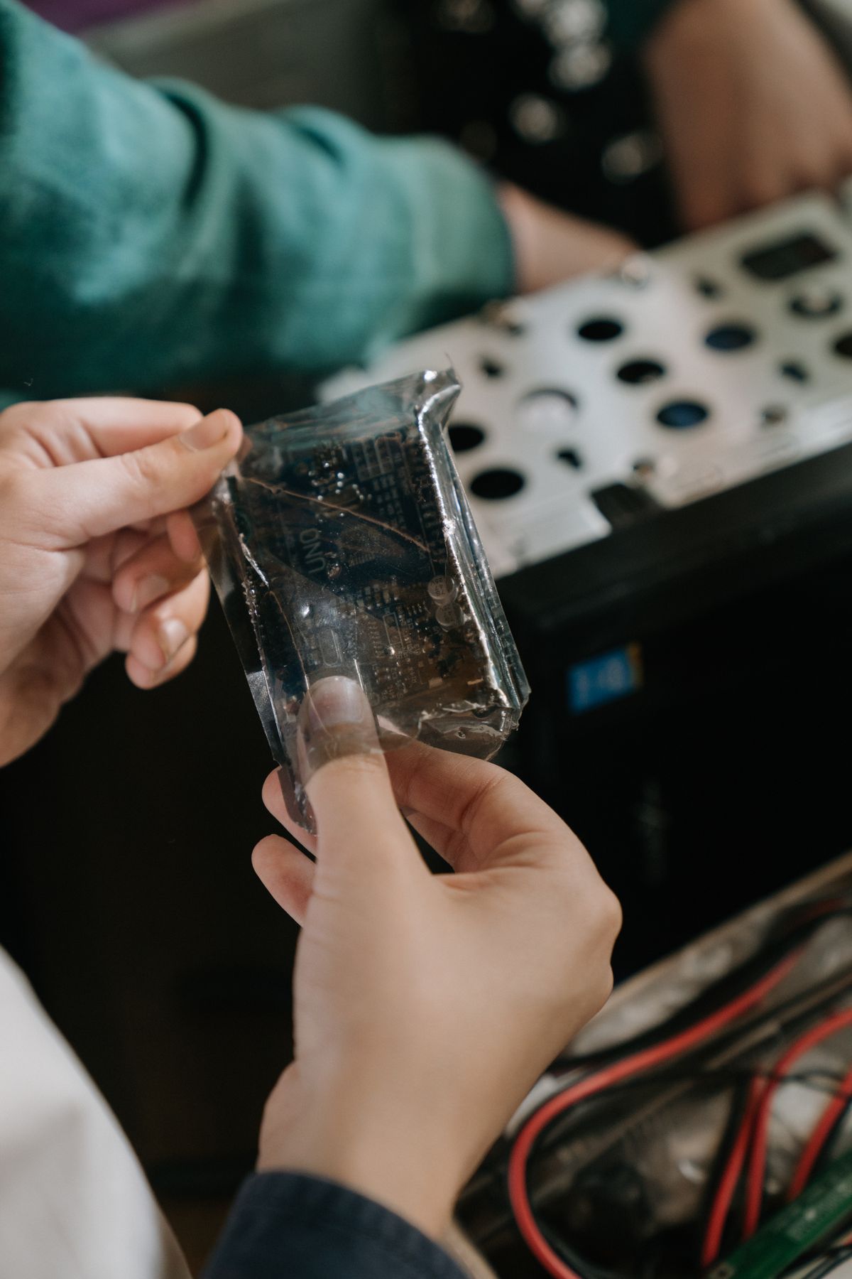 Close-up of technician hands holding a microchip in a computer hardware repair setting