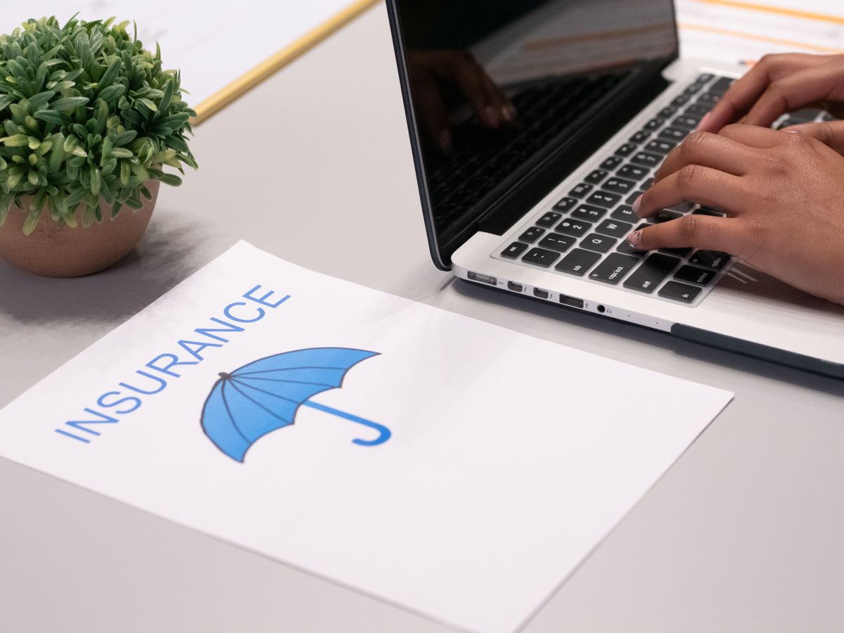 Person reviewing insurance documents on laptop representing Bitcoin mining insurance coverage