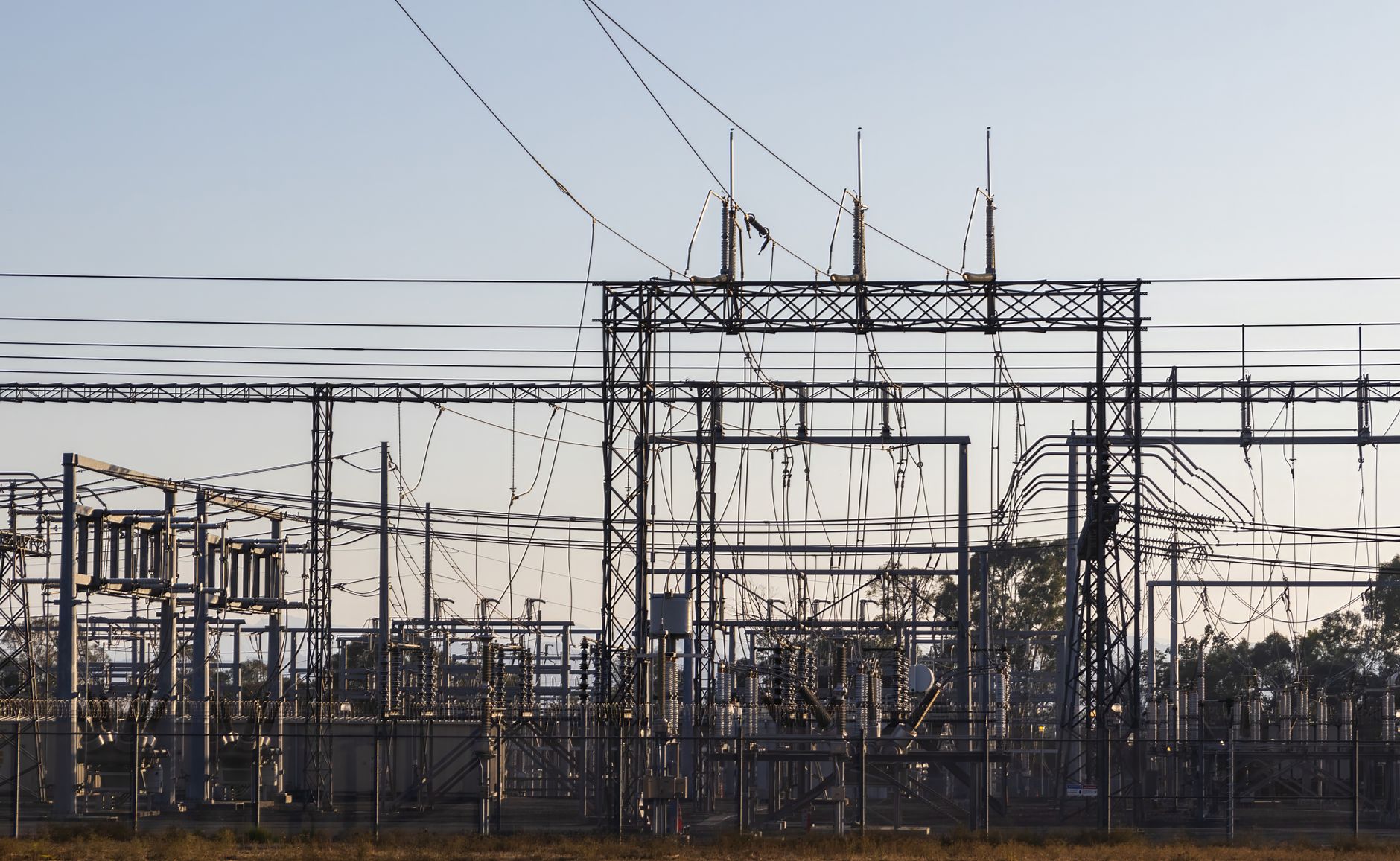 High-voltage electrical substation with power lines at dawn representing mining infrastructure