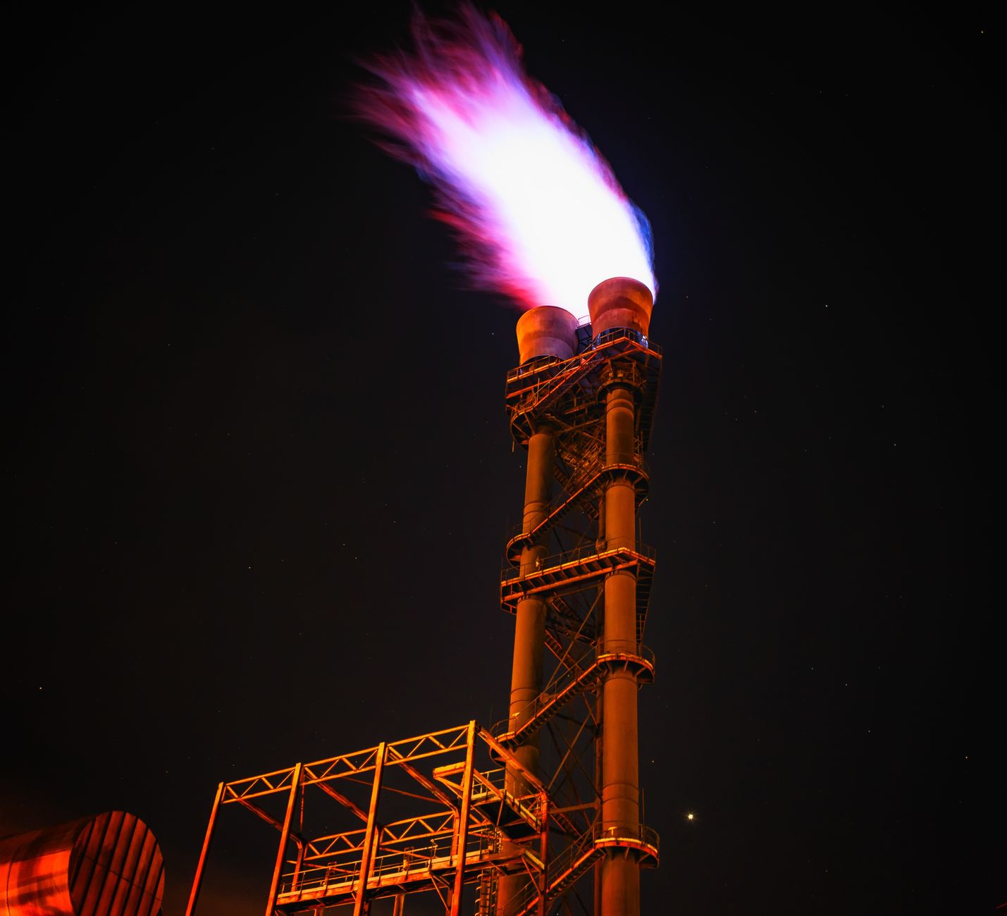 Dramatic night photo of gas flare on industrial facility emi
