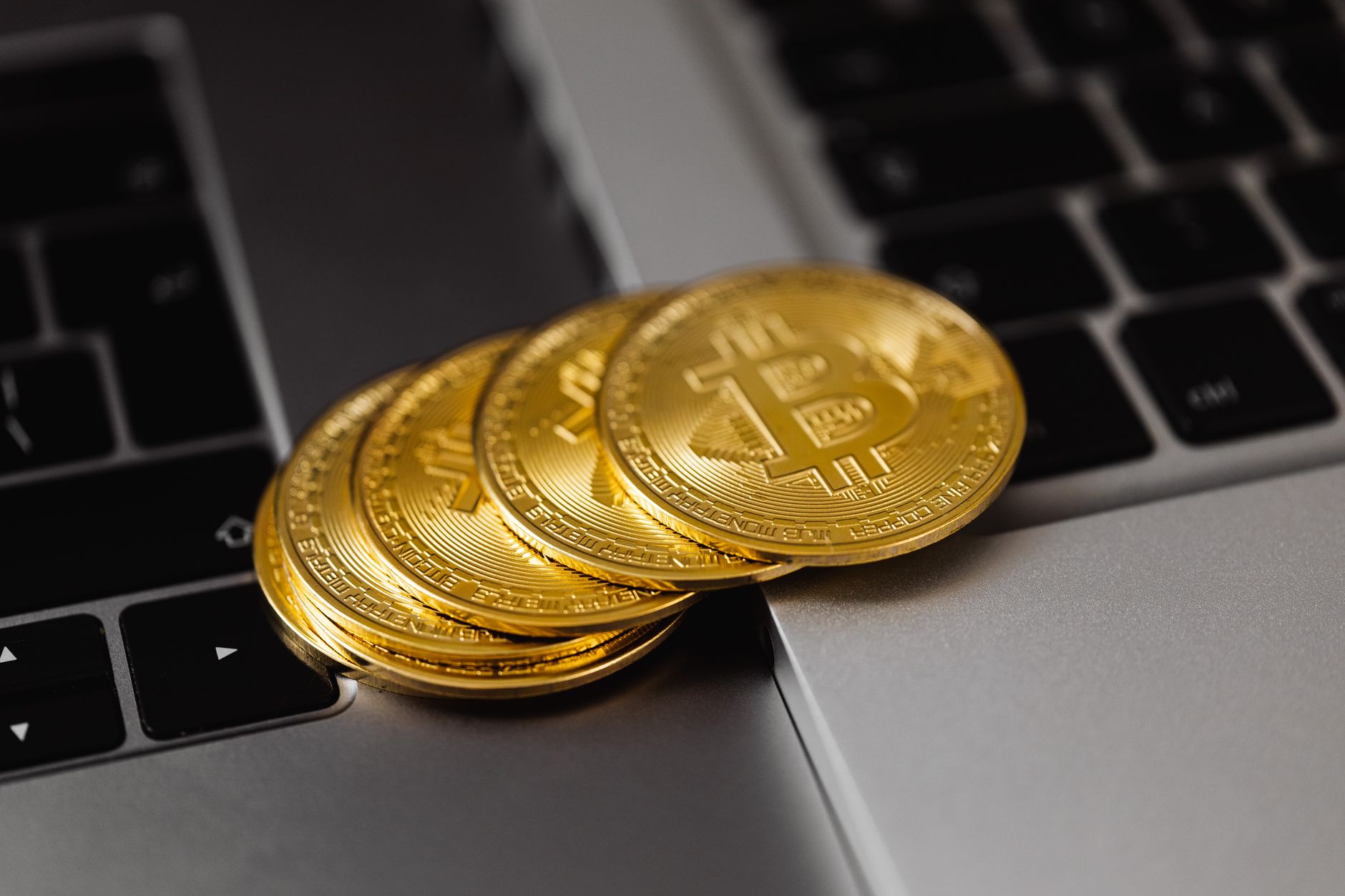 Close-up of golden bitcoins on a laptop keyboard representin