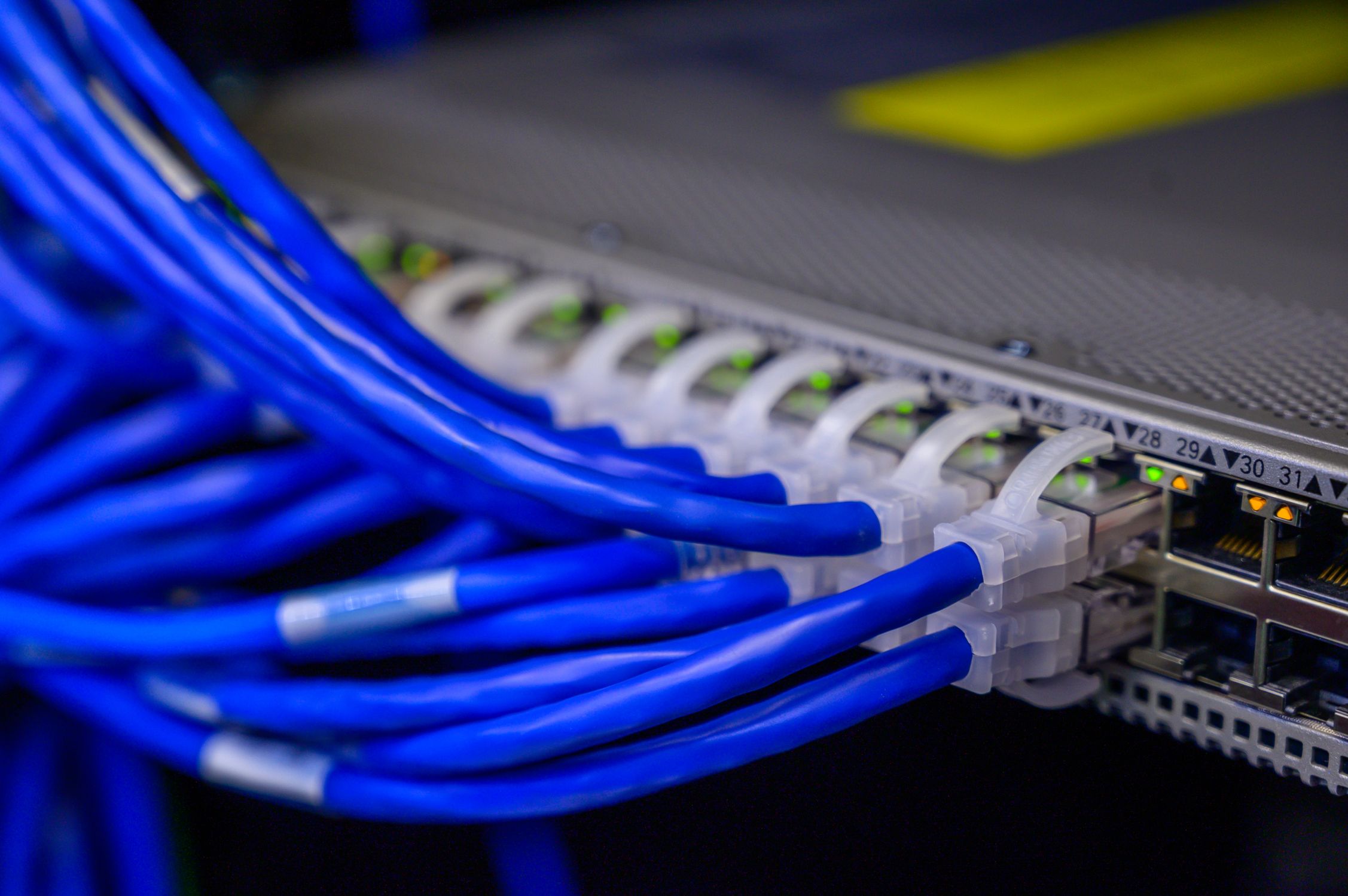 Server rack with network cables and fiber optic connections - Rax Mining