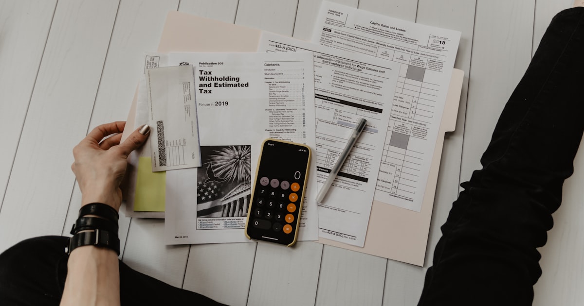Tax documents and calculator representing Bitcoin mining tax obligations for hosted mining operations