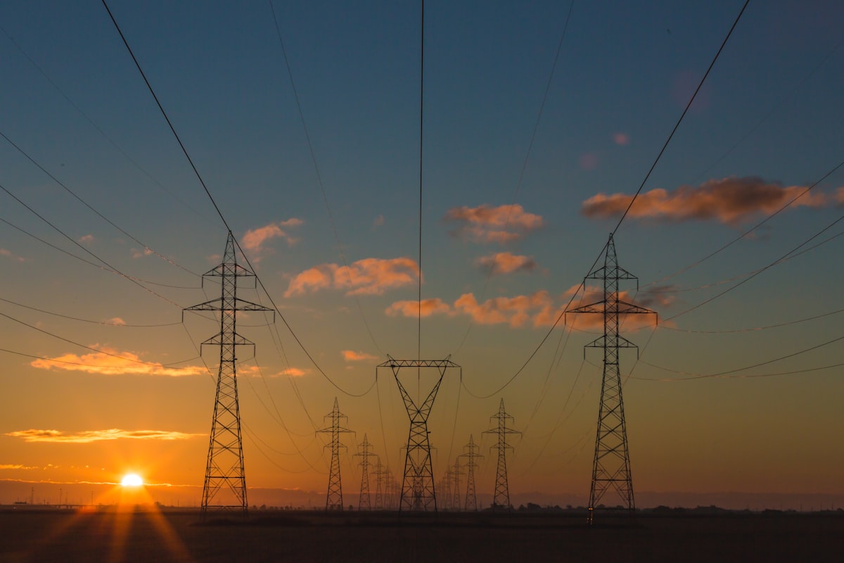 Power transmission lines at sunset representing energy arbitrage and load shifting strategies for Bitcoin mining operations