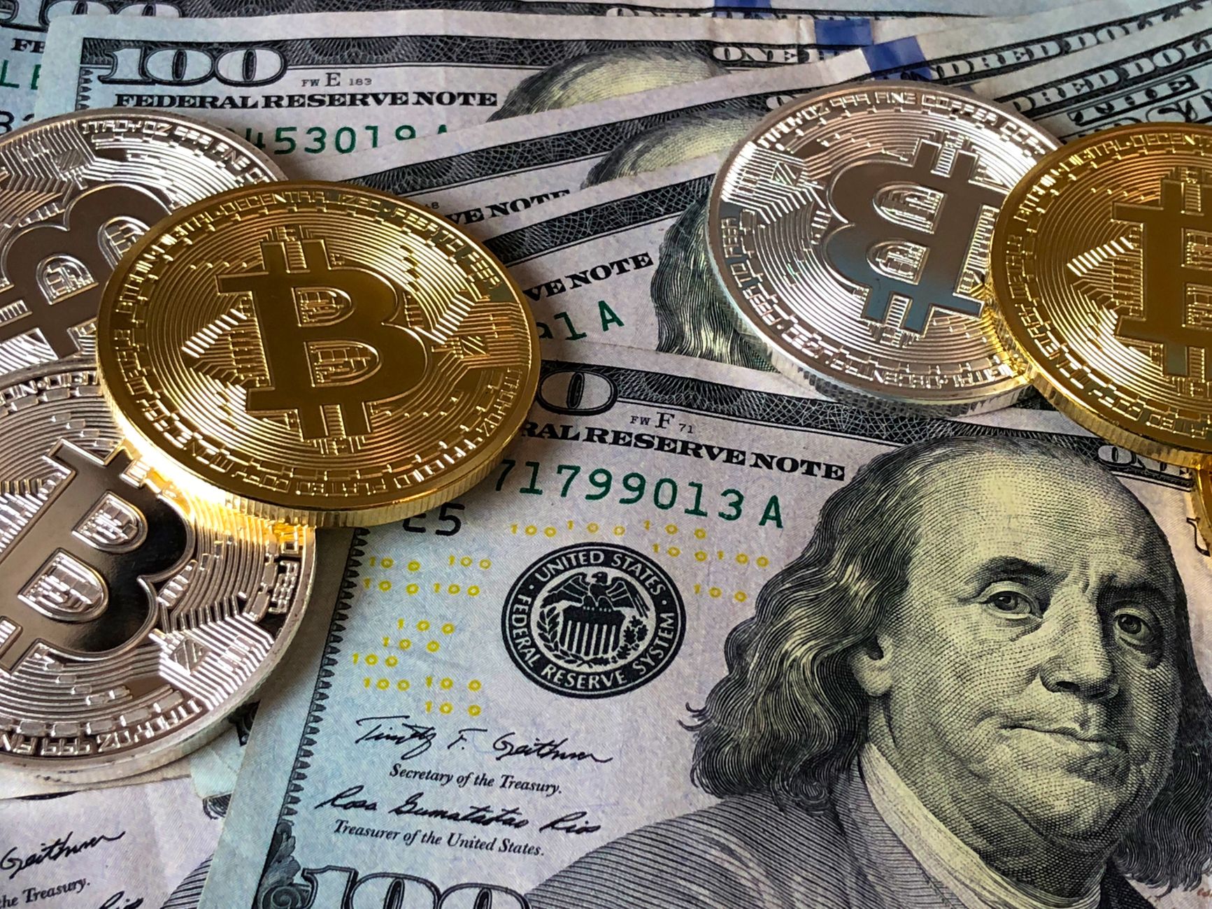 Gold Bitcoin coins stacked on a financial chart representing investment comparison between mining and buying