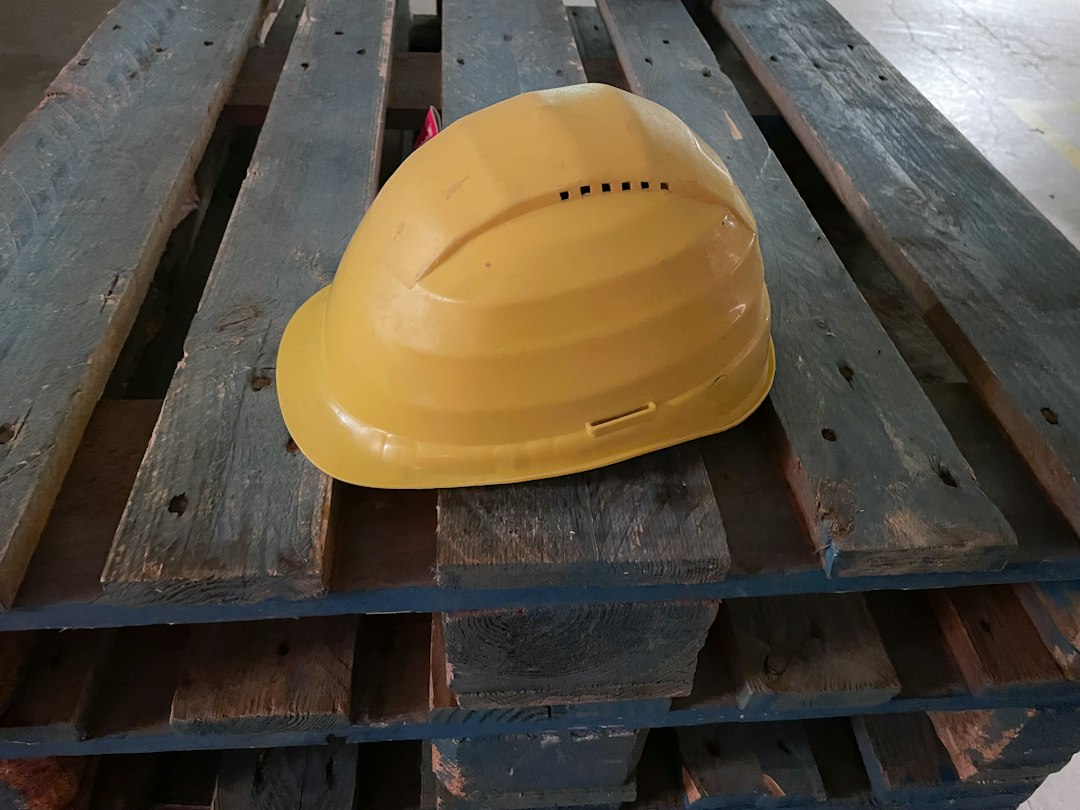 Hard hat resting on a wooden pallet at an industrial work site