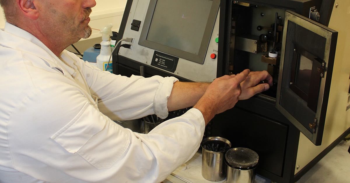 Technician loading an engine oil sample into an analysis spectrometer